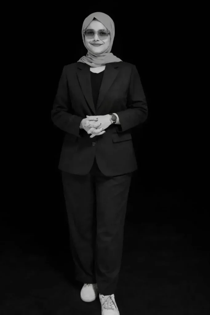 Fathimath Lamiya, a digital marketing strategist in Kannur, standing confidently in a professional outfit against a dark background.